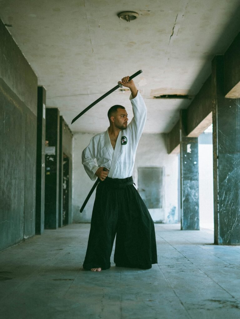 Martial artist practicing sword techniques in an urban indoor setting, showcasing skills and strength.